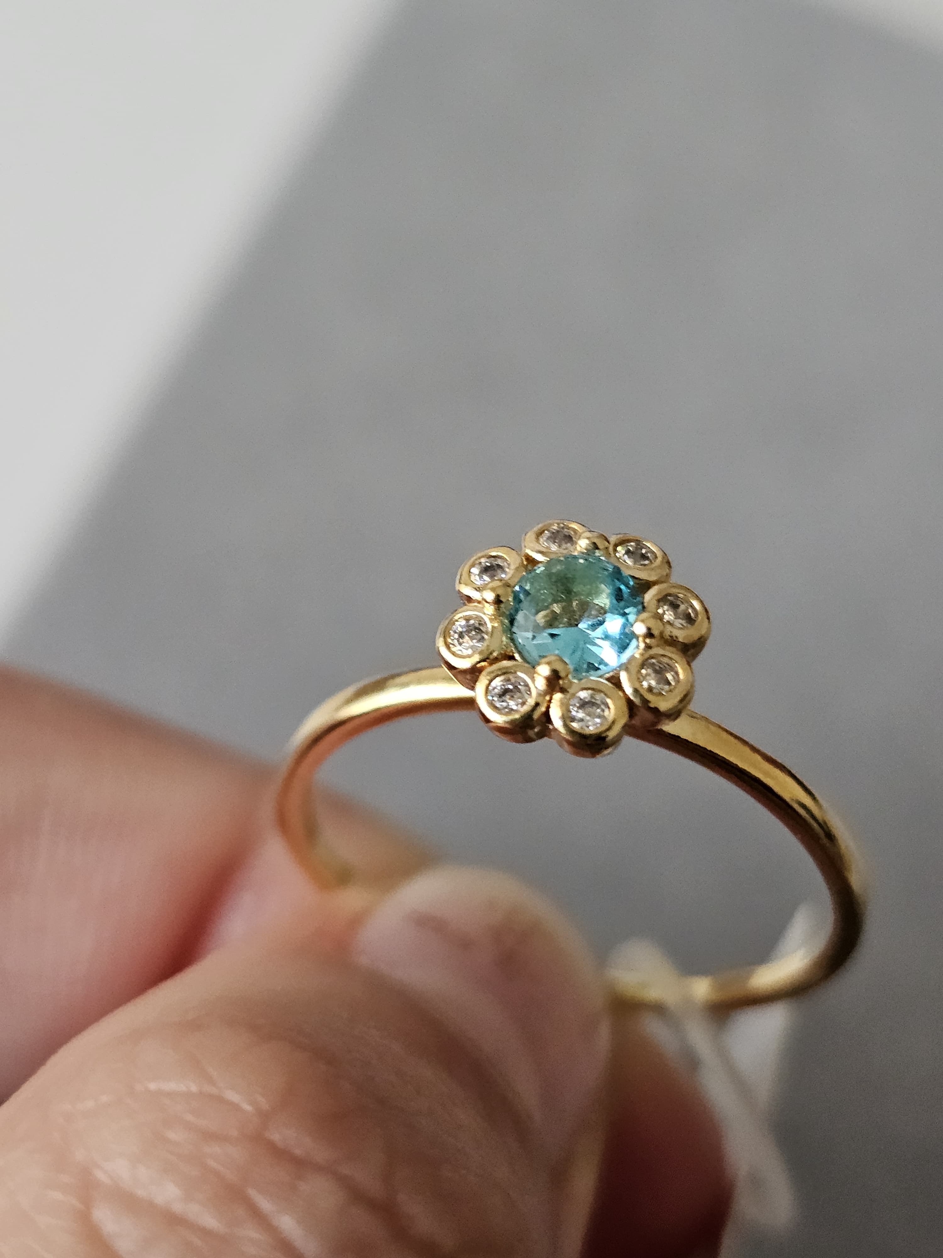 Anel de flores cravejado em zircônia, com pingo de safira, banhado a ouro 18k e com verniz antialérgico 🌸💙.