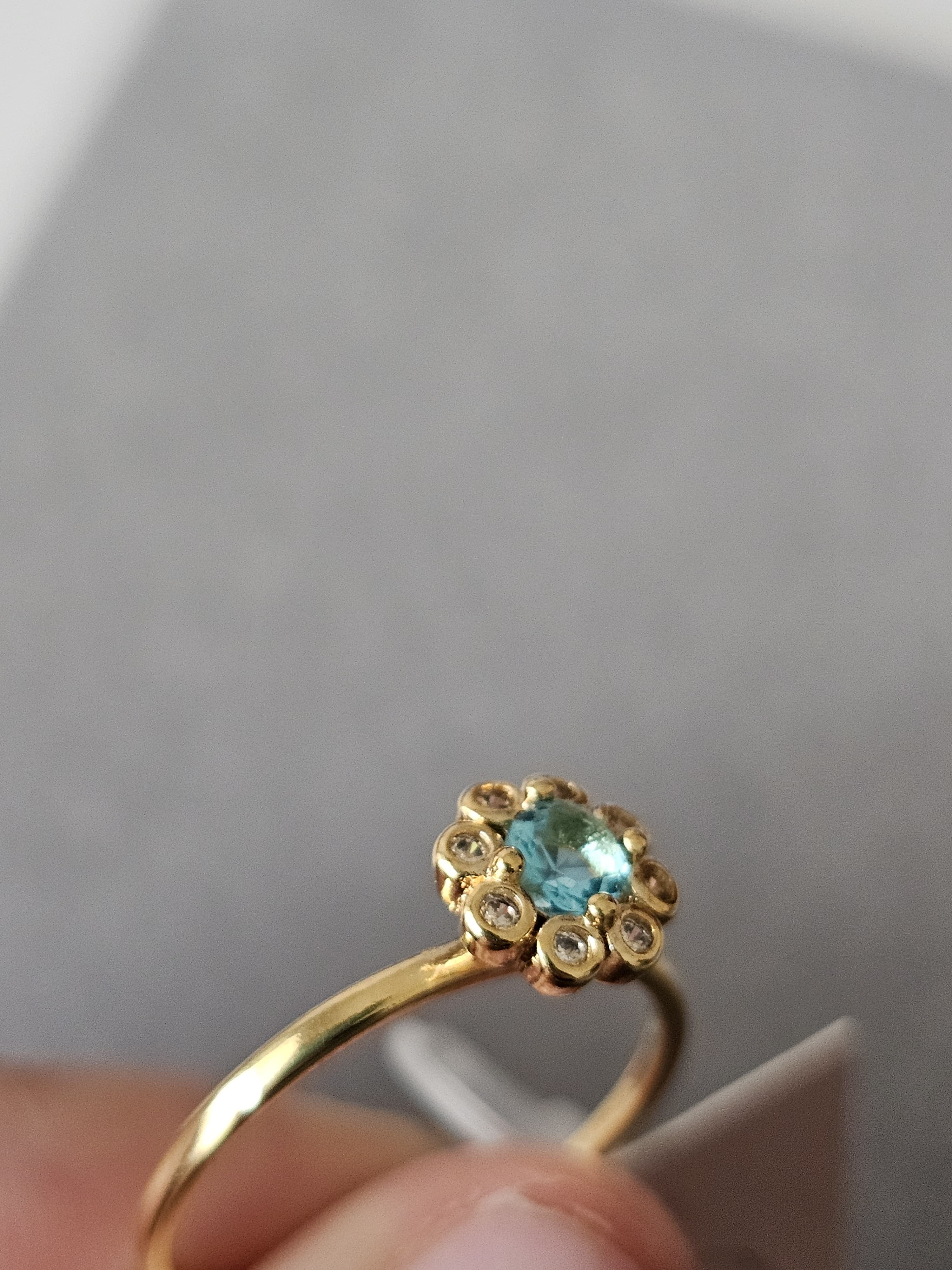 Anel de flores cravejado em zircônia, com pingo de safira, banhado a ouro 18k e com verniz antialérgico 🌸💙.