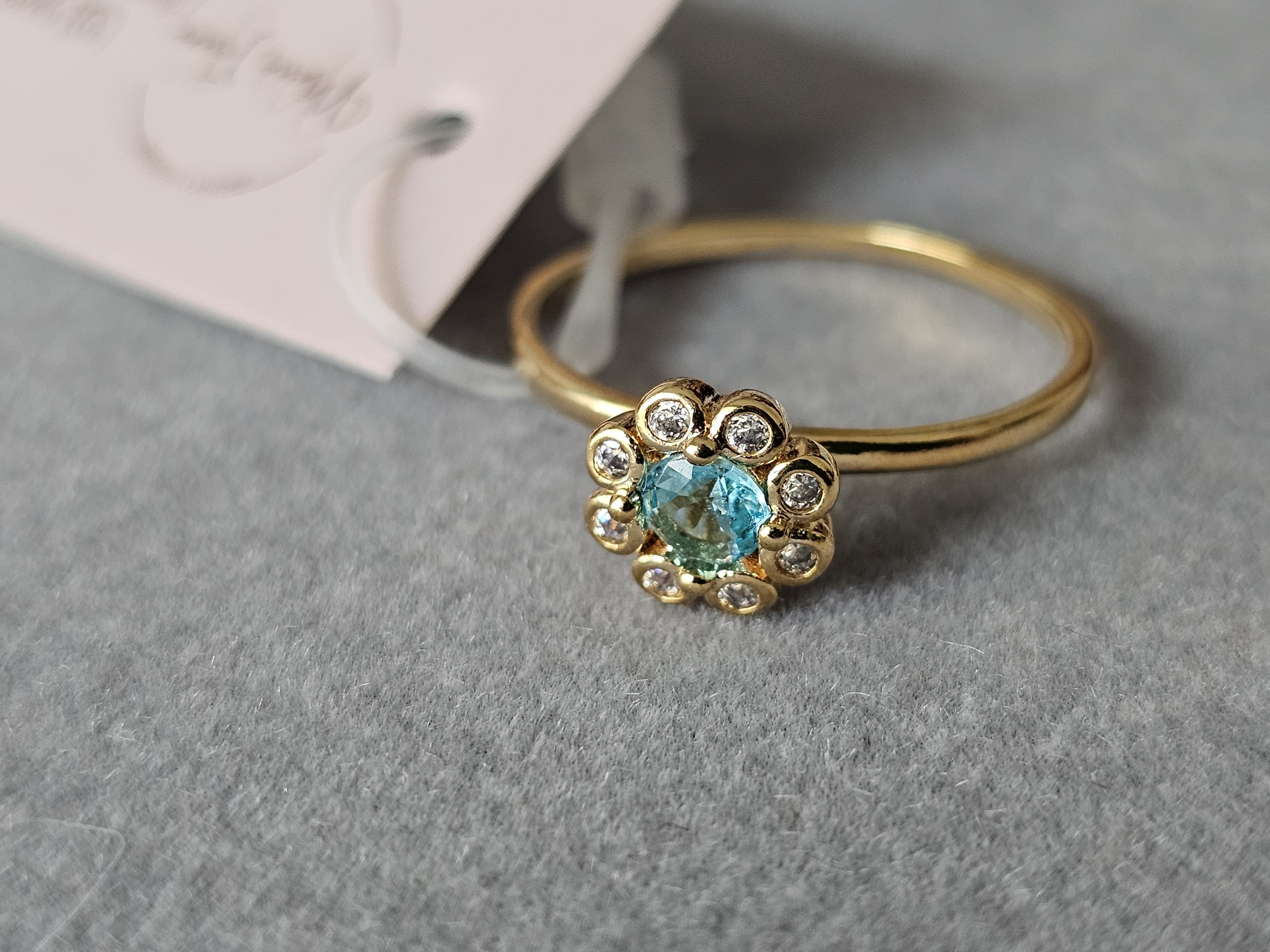 Anel de flores cravejado em zircônia, com pingo de safira, banhado a ouro 18k e com verniz antialérgico 🌸💙.