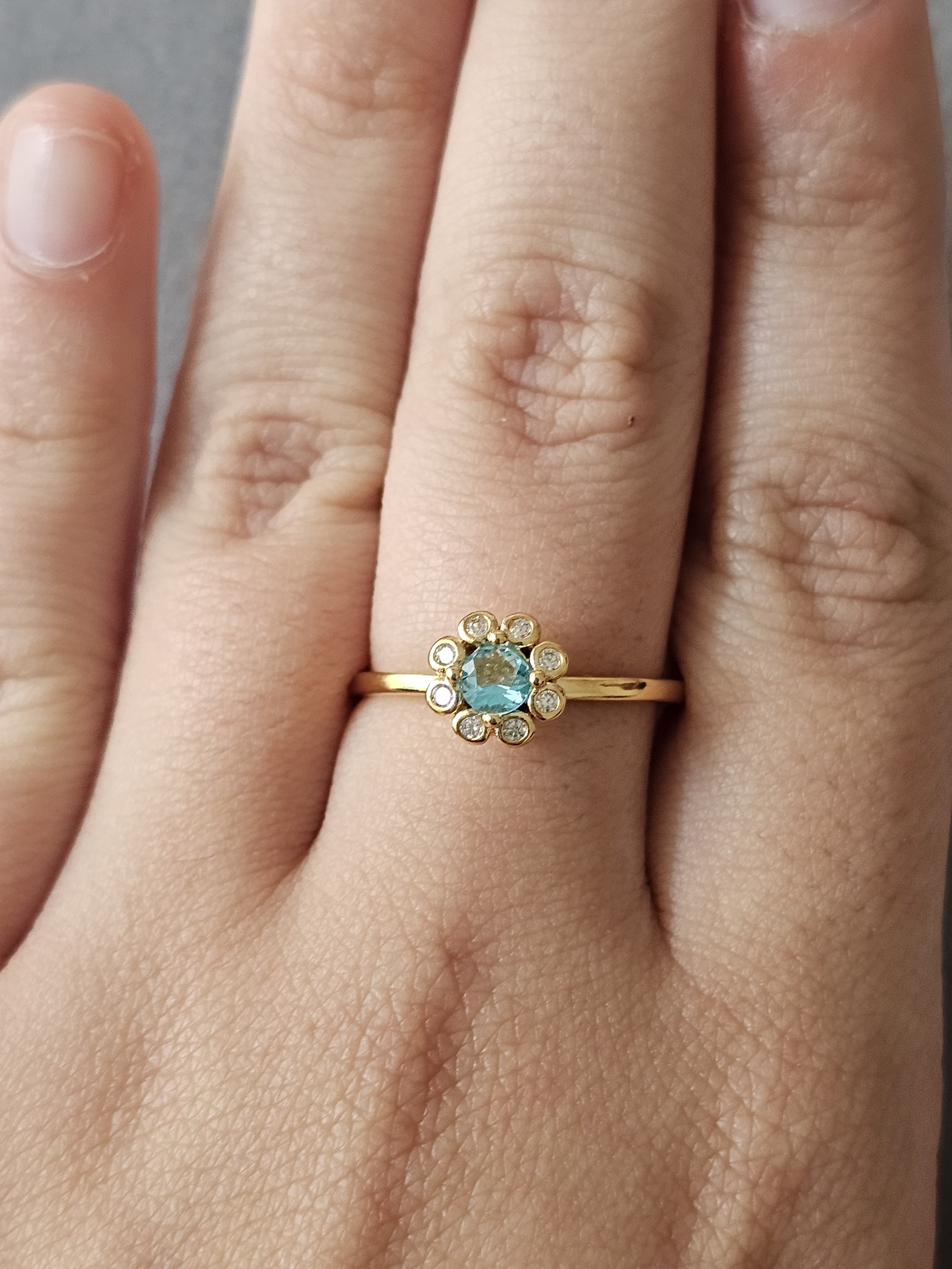 Anel de flores cravejado em zircônia, com pingo de safira, banhado a ouro 18k e com verniz antialérgico 🌸💙.