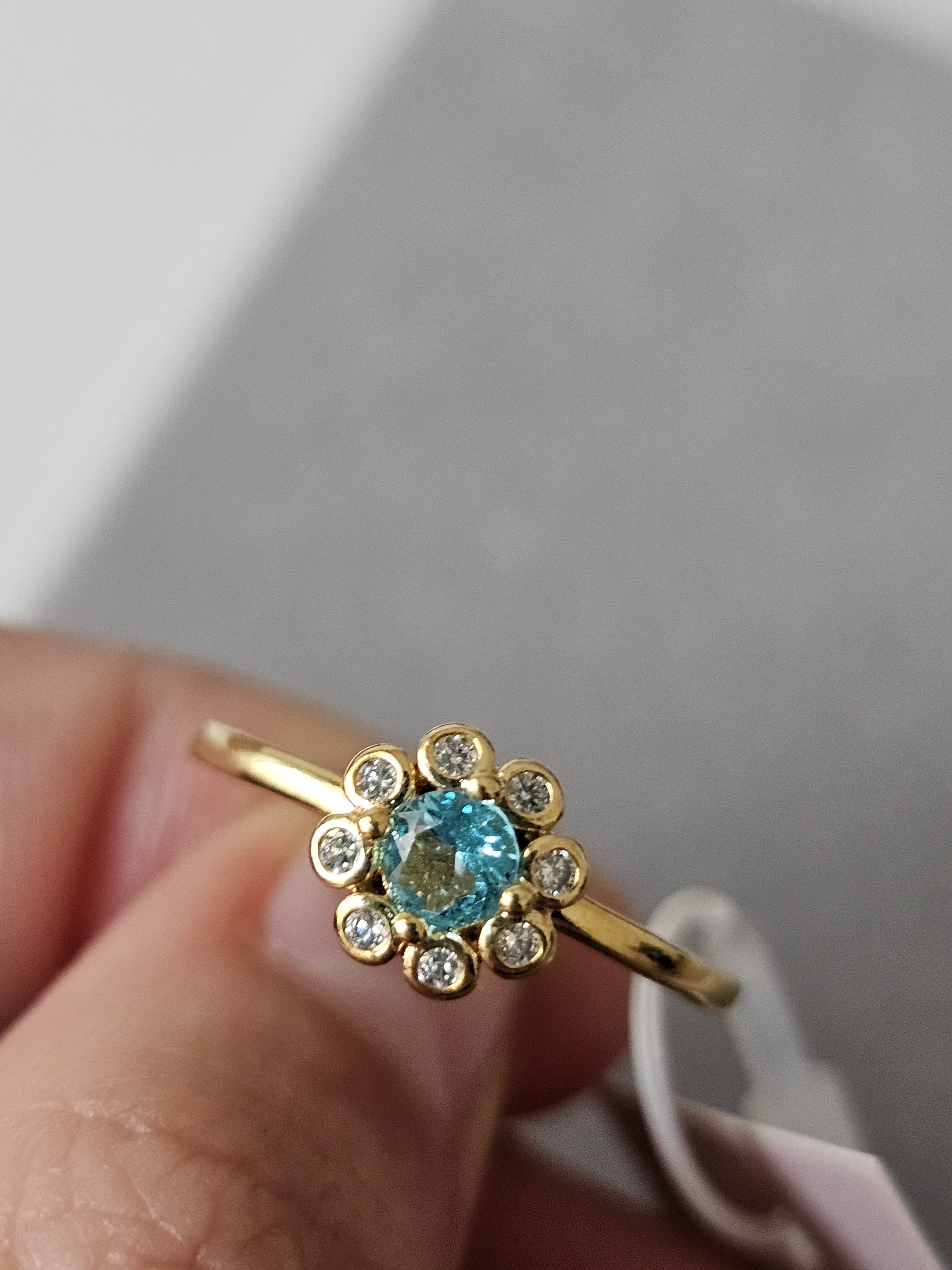 Anel de flores cravejado em zircônia, com pingo de safira, banhado a ouro 18k e com verniz antialérgico 🌸💙.
