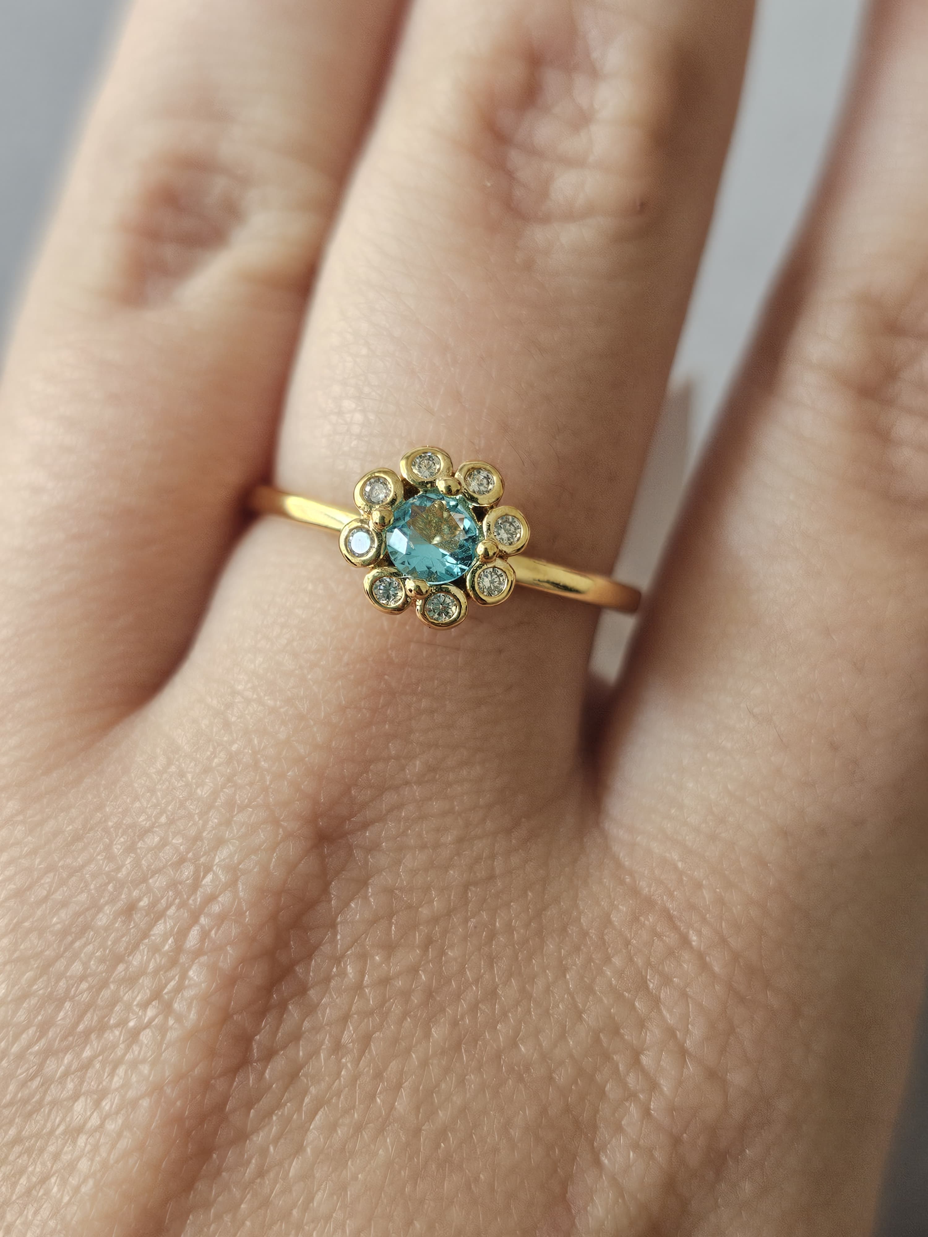 Anel de flores cravejado em zircônia, com pingo de safira, banhado a ouro 18k e com verniz antialérgico 🌸💙.