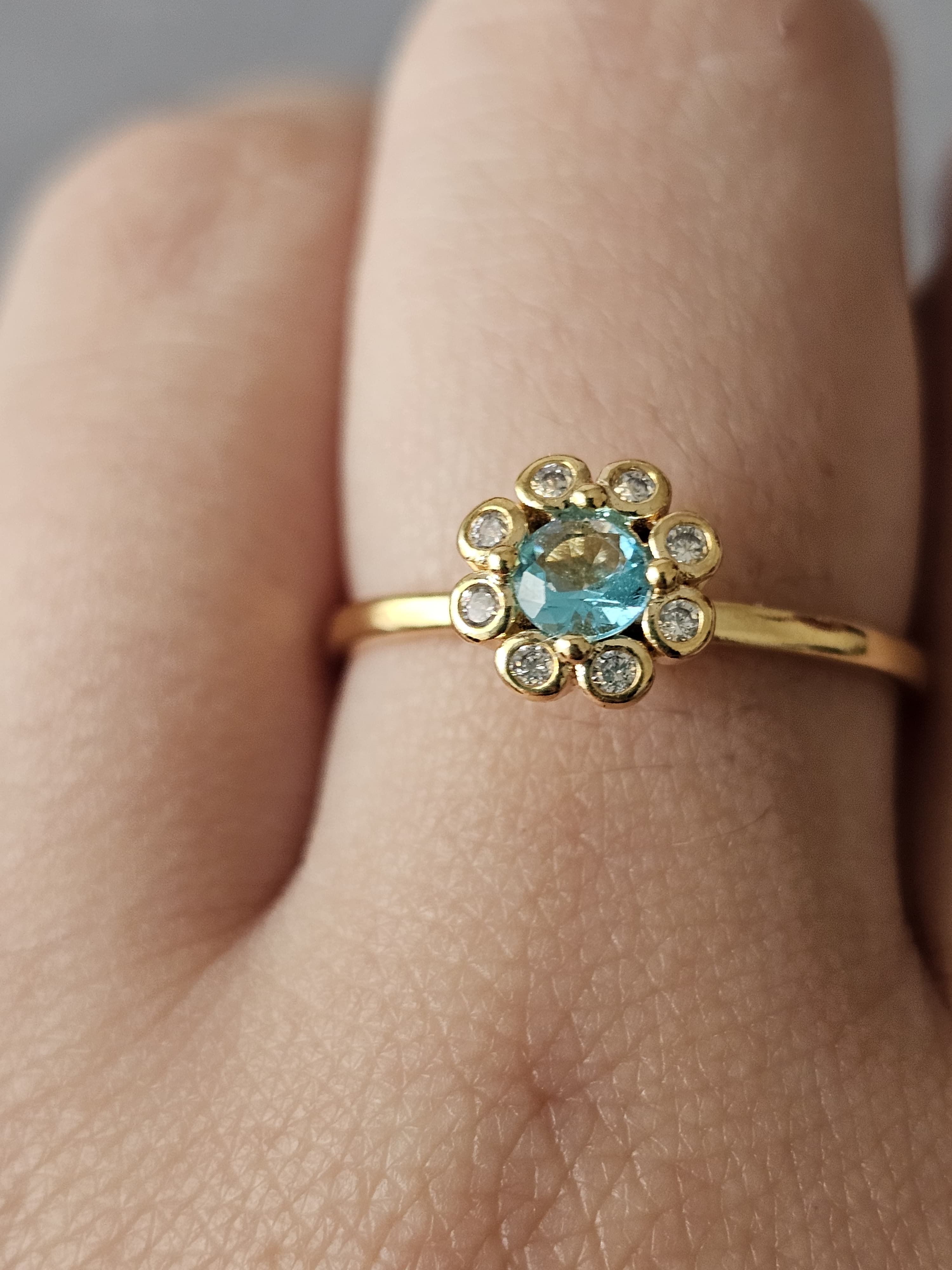 Anel de flores cravejado em zircônia, com pingo de safira, banhado a ouro 18k e com verniz antialérgico 🌸💙.