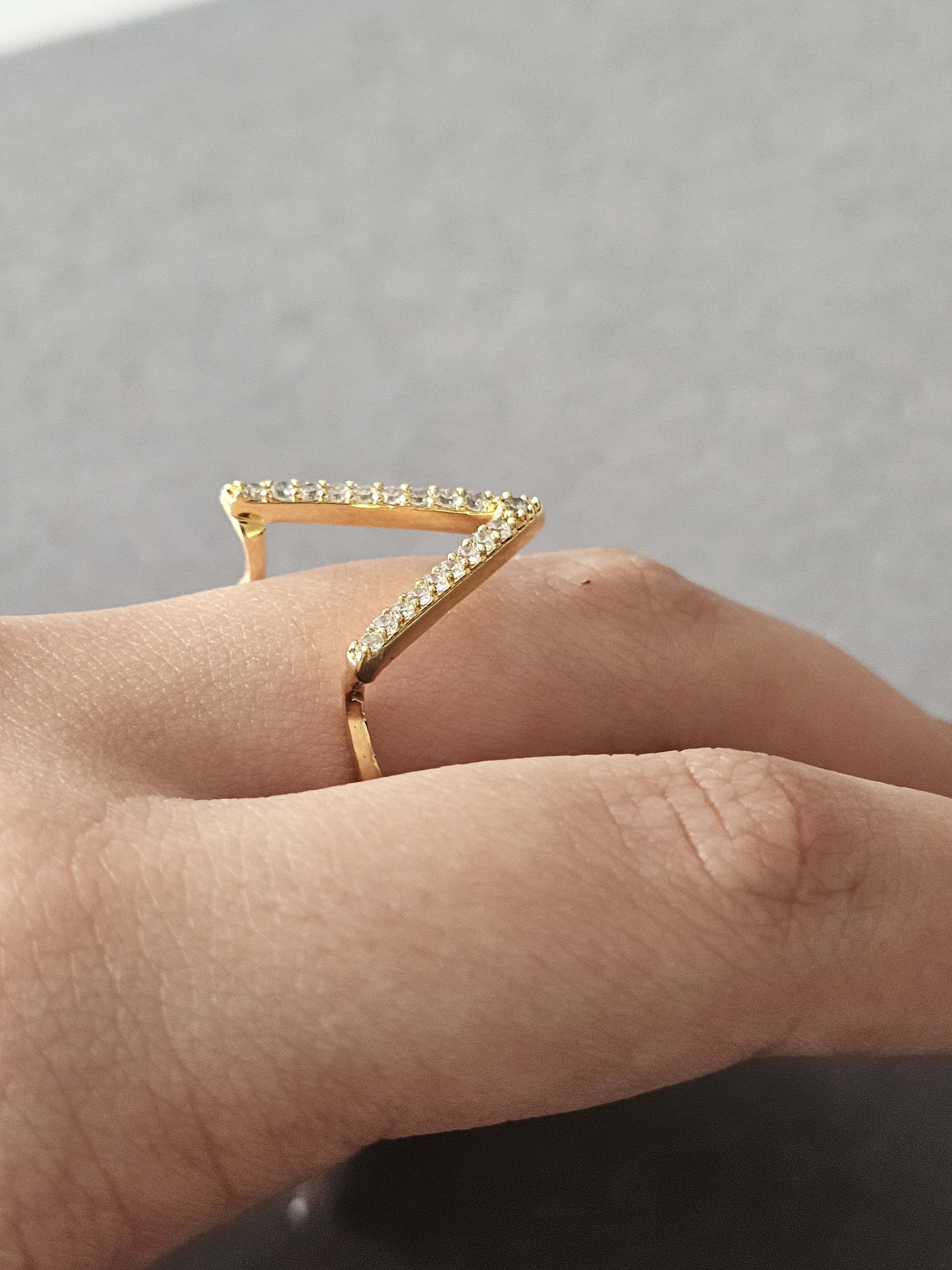 Anel cravejado em zircônia com design em "V", banhado a ouro 18k e com verniz antialérgico ✨💎.