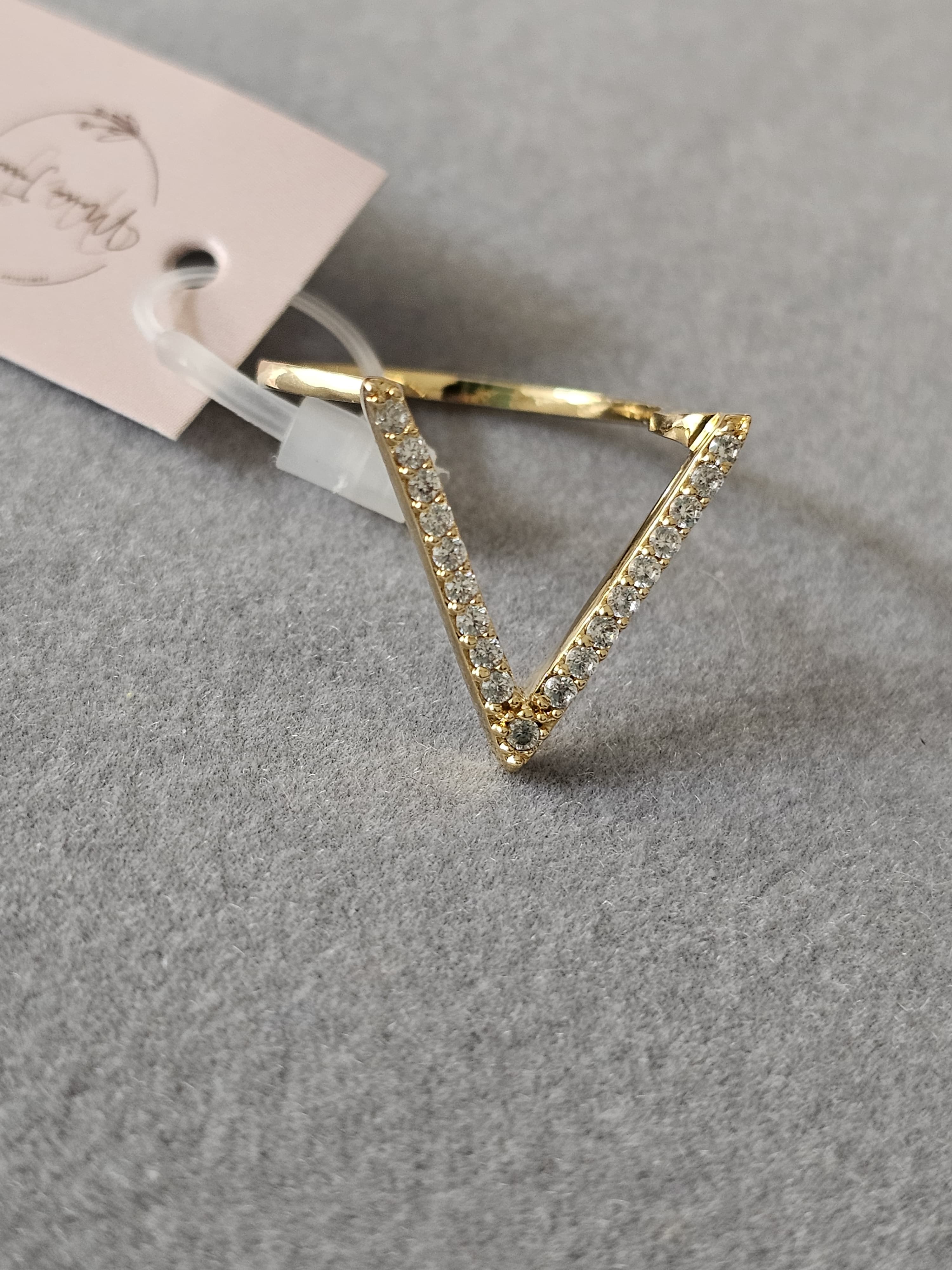 Anel cravejado em zircônia com design em "V", banhado a ouro 18k e com verniz antialérgico ✨💎.
