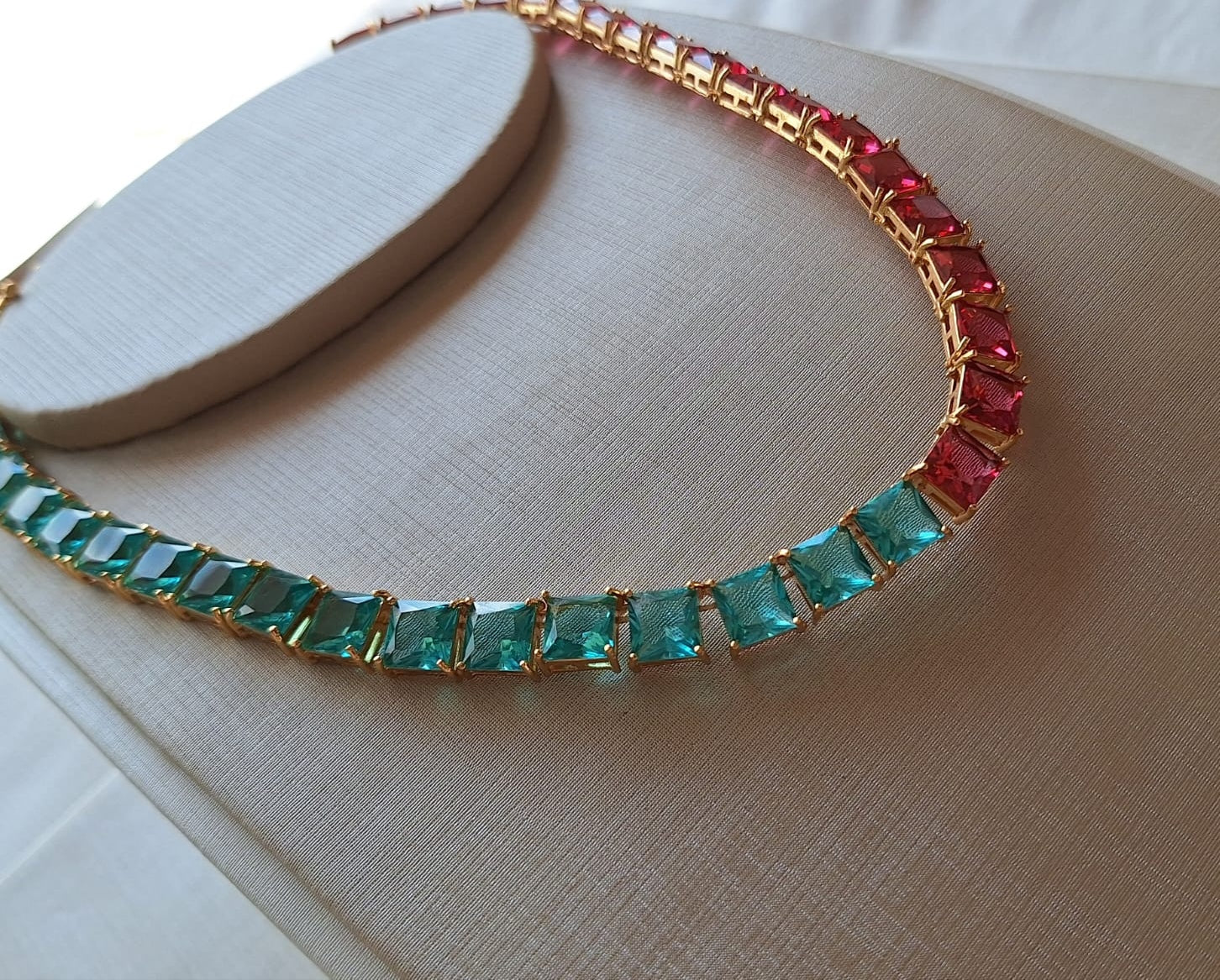 Choker cravejada em rubi e esmeralda, banhada a ouro 18k e com verniz antialérgico 💚✨.